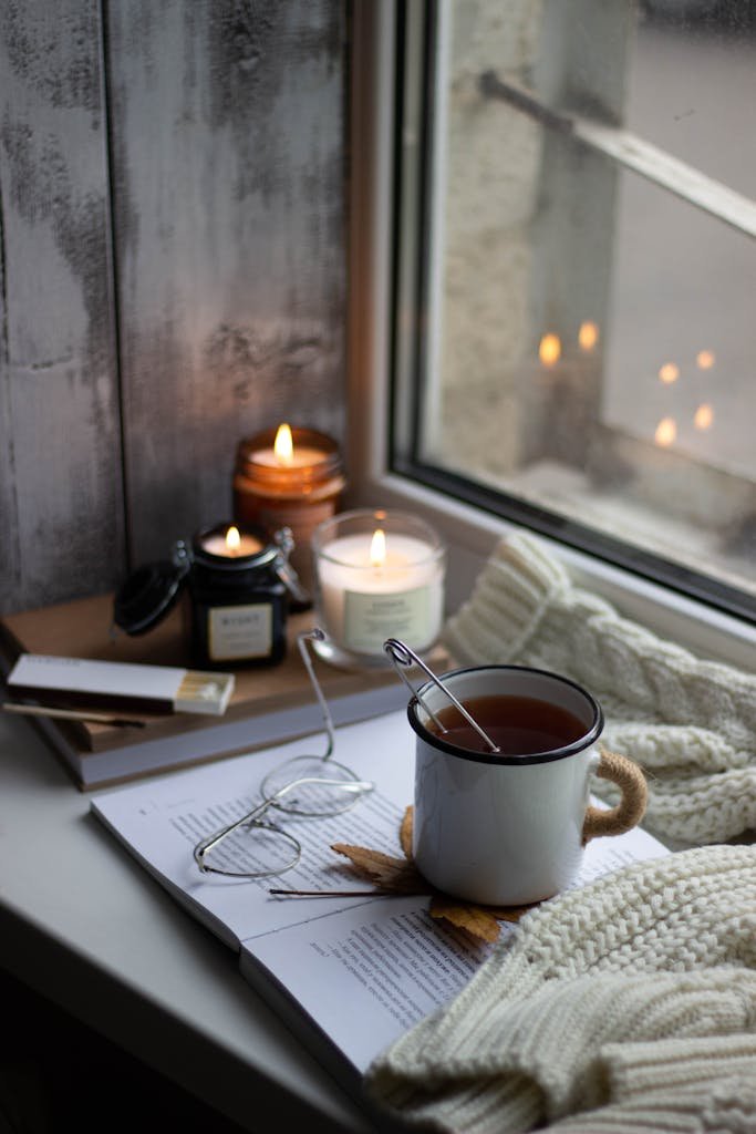 Windowsill with Autumnal Decorations, a Book, Eyeglasses and a Cup of Tea