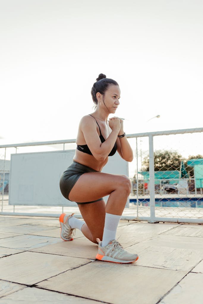 A woman doing squats in front of a pool