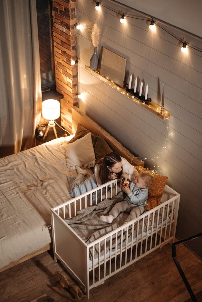Mother and child in a warmly lit bedroom, enjoying quiet time together.